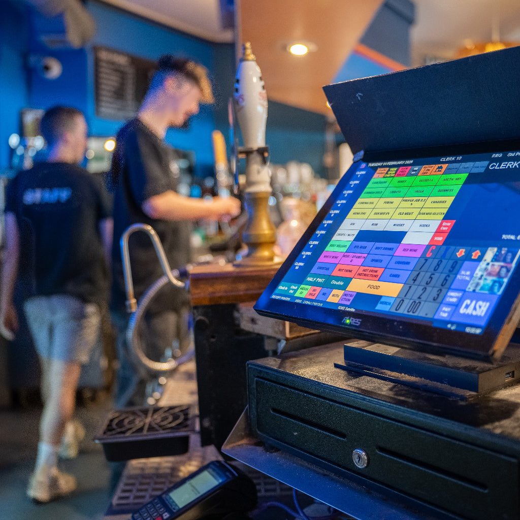 POS system on a counter with bar staff in the background