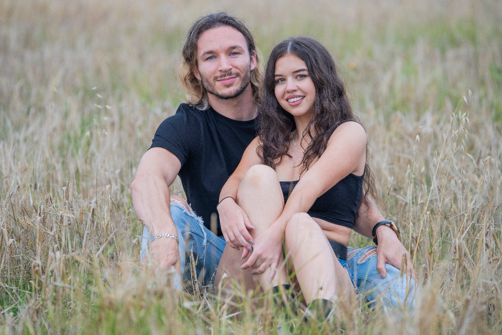 Man and woman sitting together in a grassy field