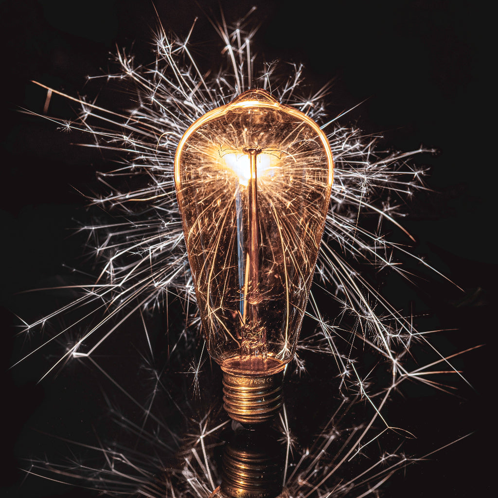 Light bulb with sparkly effect on a black background